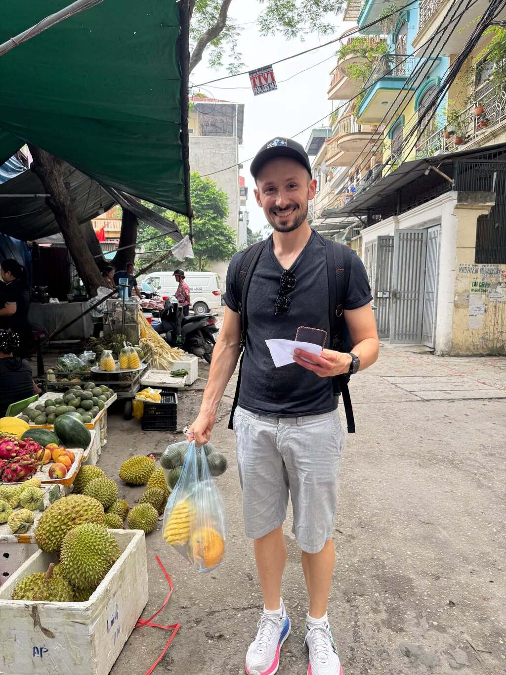 A traveller with a bag of fruit from a street fruit stall