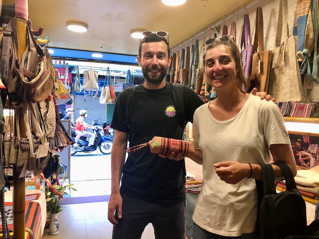 A couple shopping for handmade bags in a souvenir store, a good place for bargaining in Vietnam