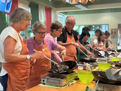 Travellers cooking at a Vietnamese cooking class in Hoi An