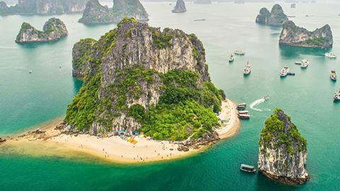Limestone islands and a small beach on Ha Long Bay from above